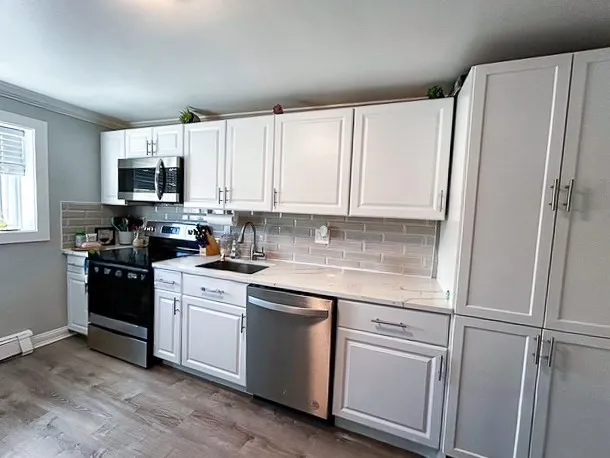 a kitchen with white cabinets and white appliances