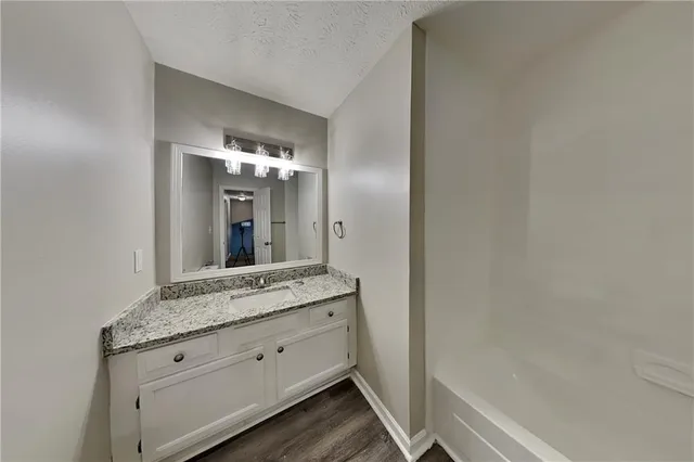a bathroom with a granite countertop sink and a mirror