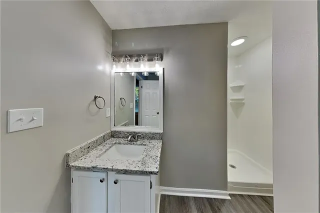 a bathroom with a granite countertop sink and a mirror