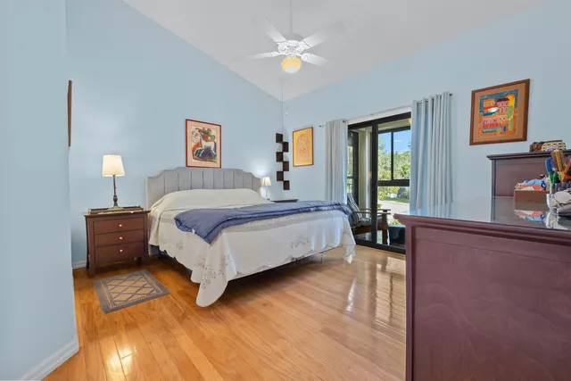 a bedroom with a bed painting on wall and a large window