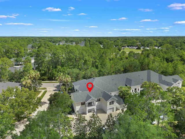 an aerial view of residential house with outdoor space and trees all around