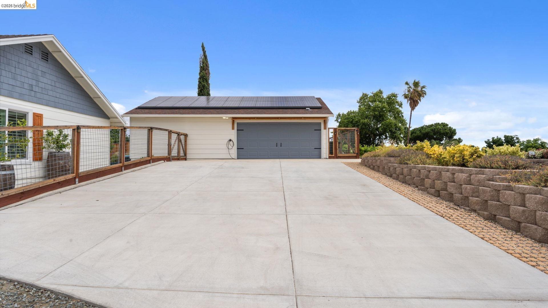 700 Brownstone Road Oakley, CA 94561 - Photo 57 of 58 Expansive concrete driveway leading to a detached garage with solar panels