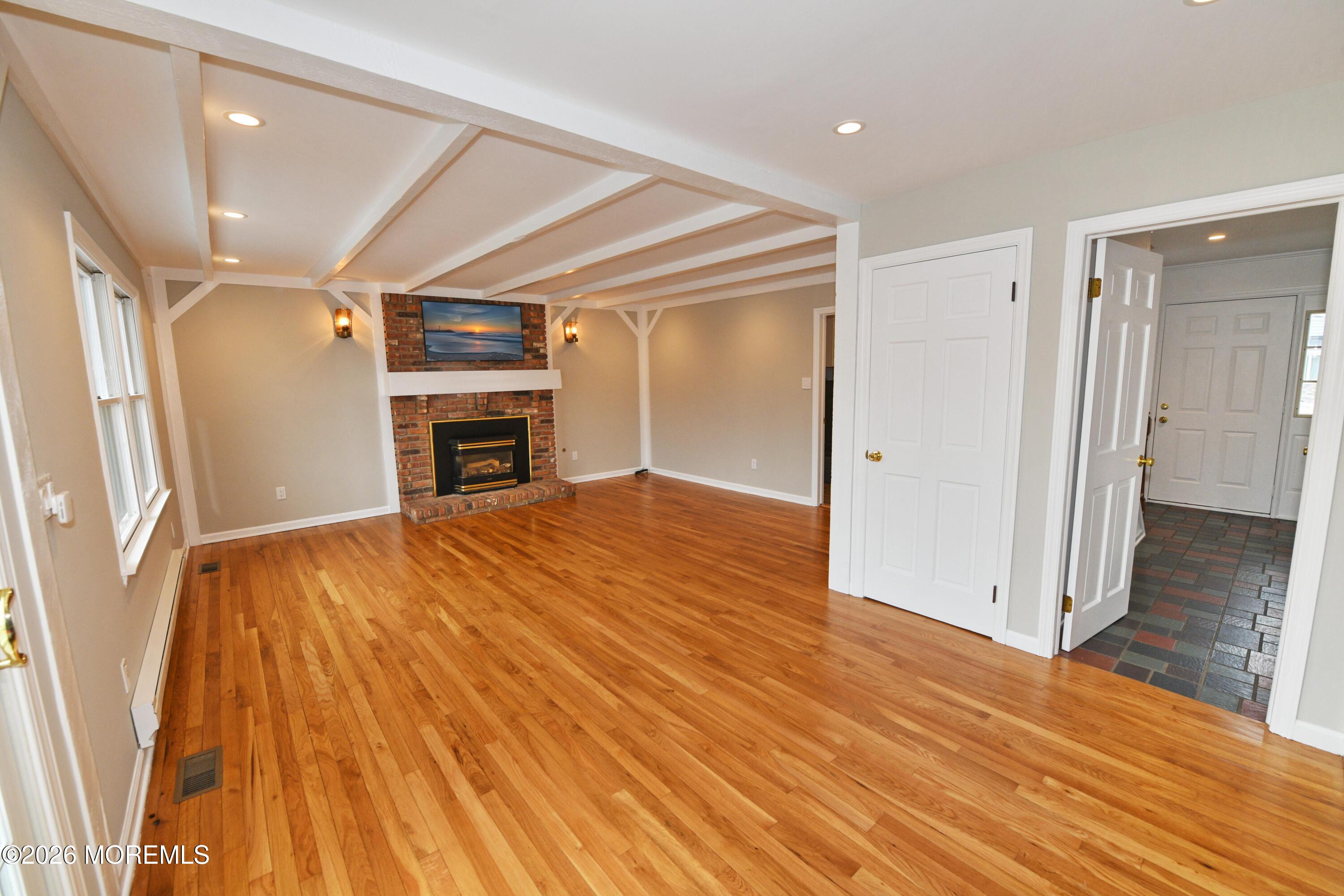 1608 Osprey Court Point Pleasant, NJ 08742 - Photo 13 of 40 wooden floor in an empty room with a fireplace