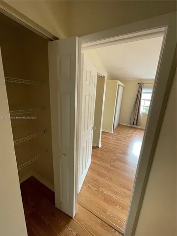 a view of a hallway with wooden floor and staircase