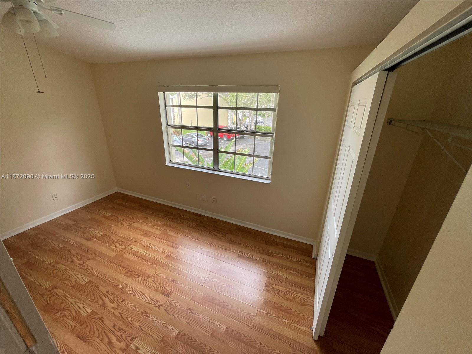 2880 Belmont Lane, Unit 2880 Cooper City, FL 33026 - Photo 9 of 16 an empty room with wooden floor and windows