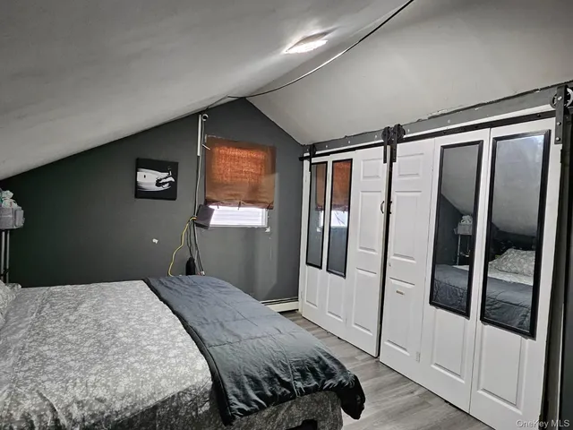 a bedroom with a bed and a large mirror