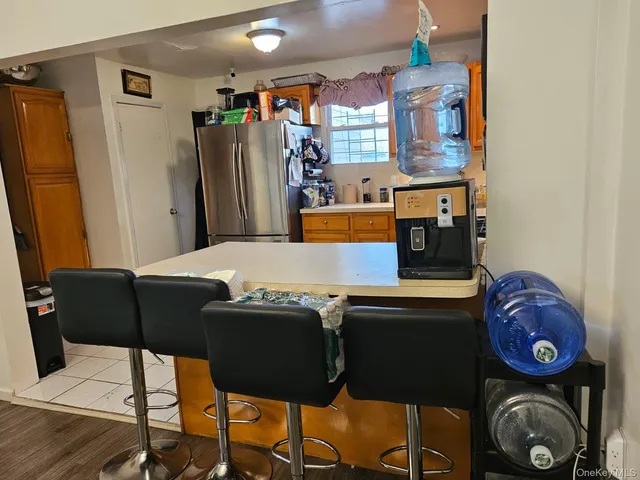 a kitchen with stainless steel appliances granite countertop a table chairs and a refrigerator