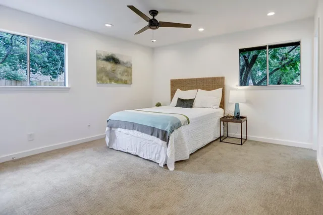 a spacious bedroom with a bed and a large window