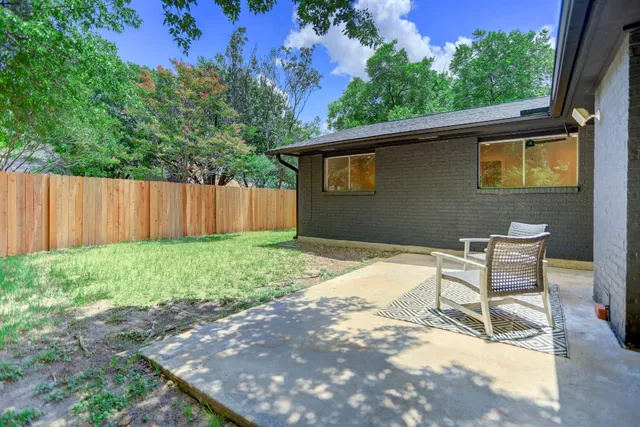 a backyard of a house with table and chairs