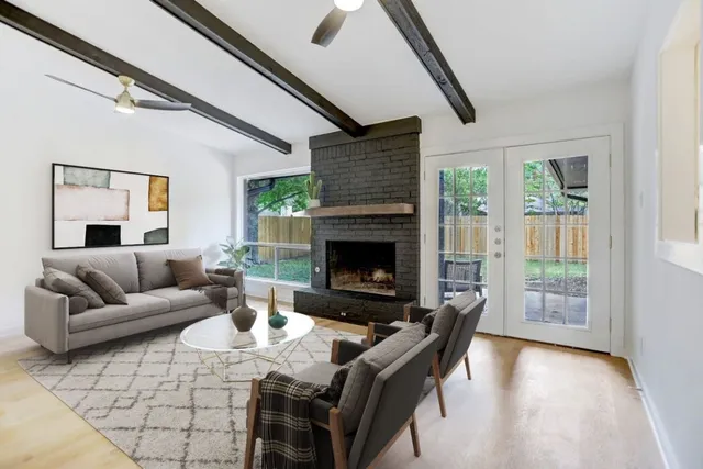 a living room with furniture a large window and a fireplace