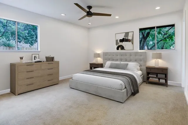 a spacious bedroom with a bed and a dresser