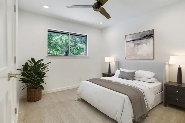 a bedroom with a large bed and a potted plant