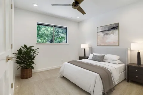 a bedroom with a large bed and a potted plant