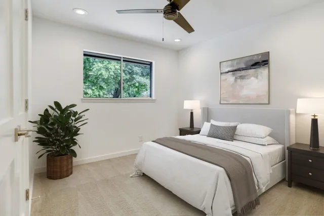 a bedroom with a large bed and a potted plant