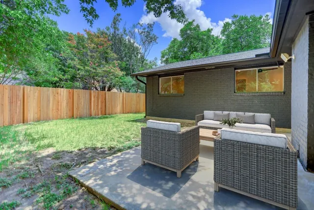 a backyard of a house with table and chairs