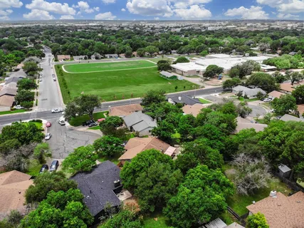 an aerial view of residential houses with outdoor space and street view