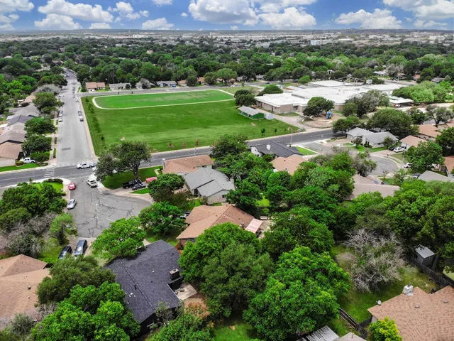 an aerial view of residential houses with outdoor space and street view