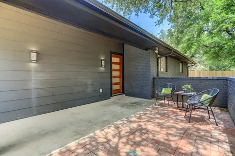 a backyard of a house with table and chairs
