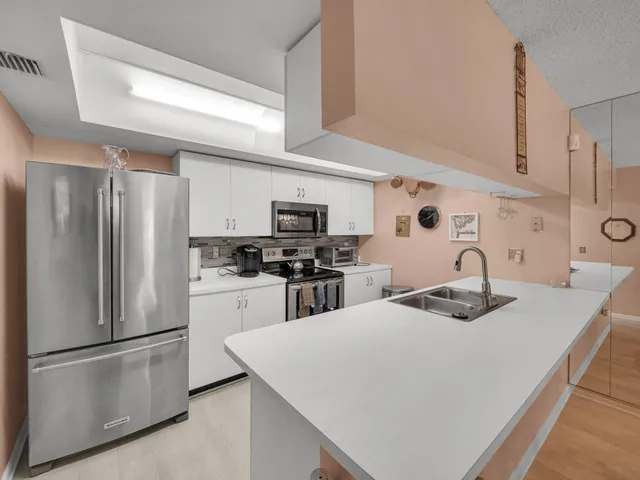a kitchen with kitchen island a refrigerator stove and sink