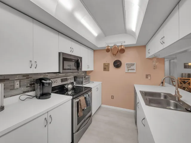 a kitchen with a sink a stove and cabinets
