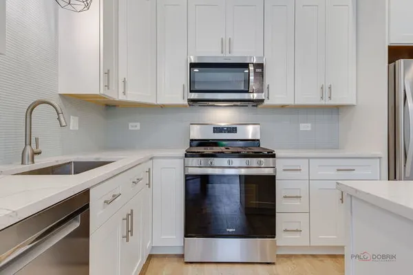 a kitchen with cabinets stainless steel appliances and a sink