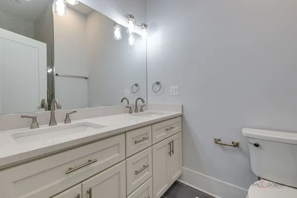 a bathroom with a double vanity sink and a toilet