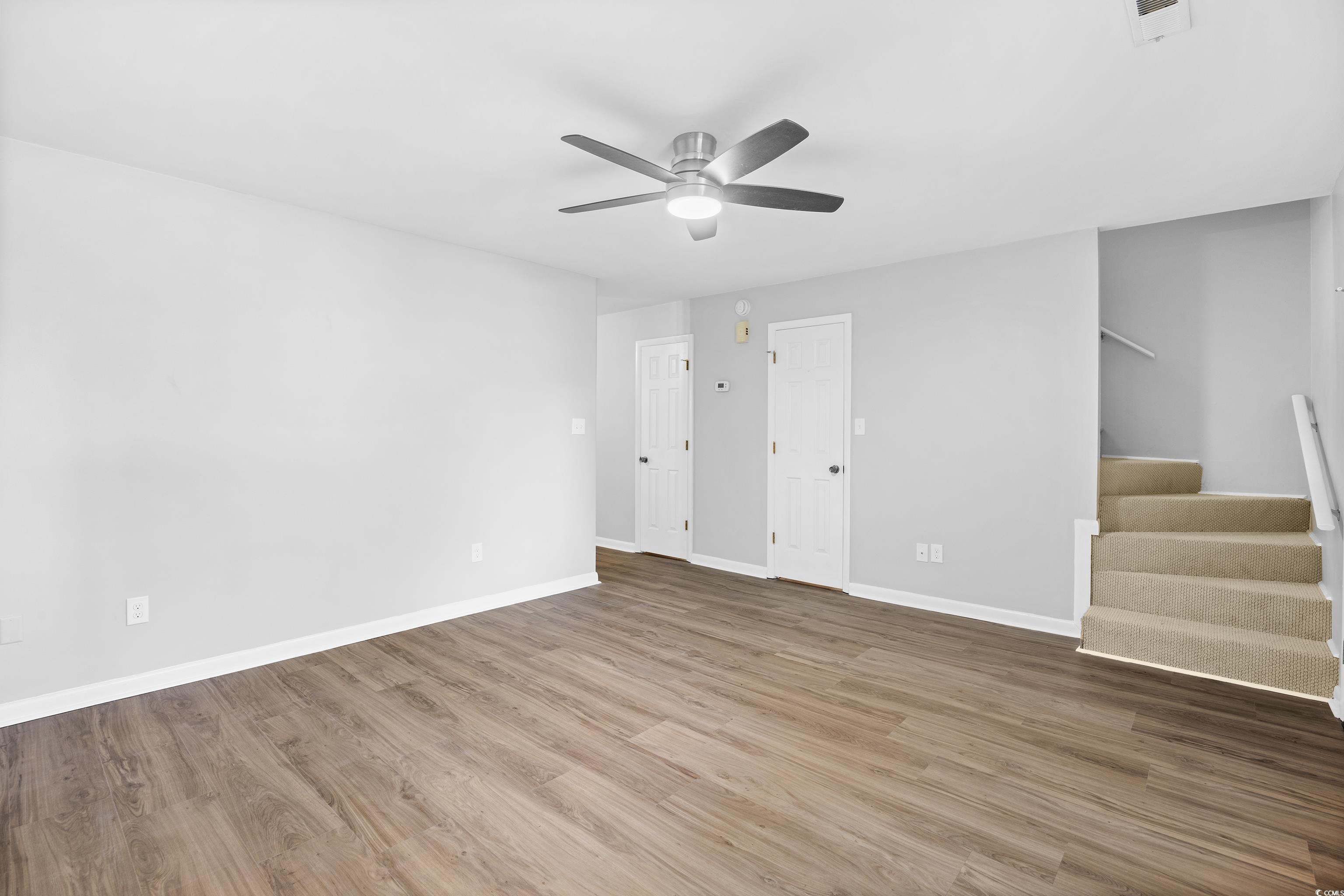 617 Surfside Drive Surfside Beach, SC 29575 - Photo 11 of 39 Unfurnished living room with light wood-style flooring, stairway, and ceiling fan