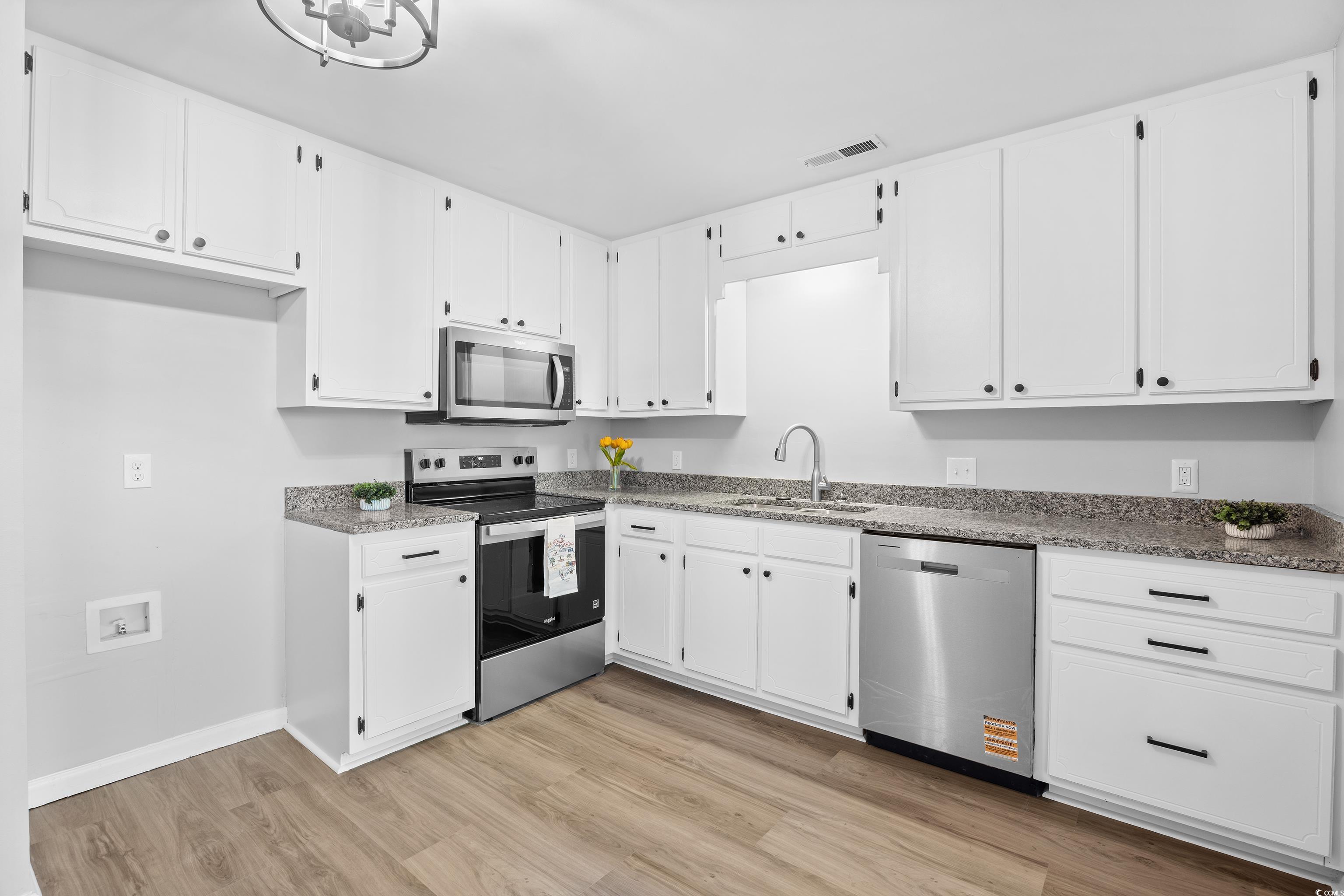 617 Surfside Drive Surfside Beach, SC 29575 - Photo 16 of 39 Kitchen featuring stainless steel appliances, white cabinets, light stone countertops, and light wood finished floors