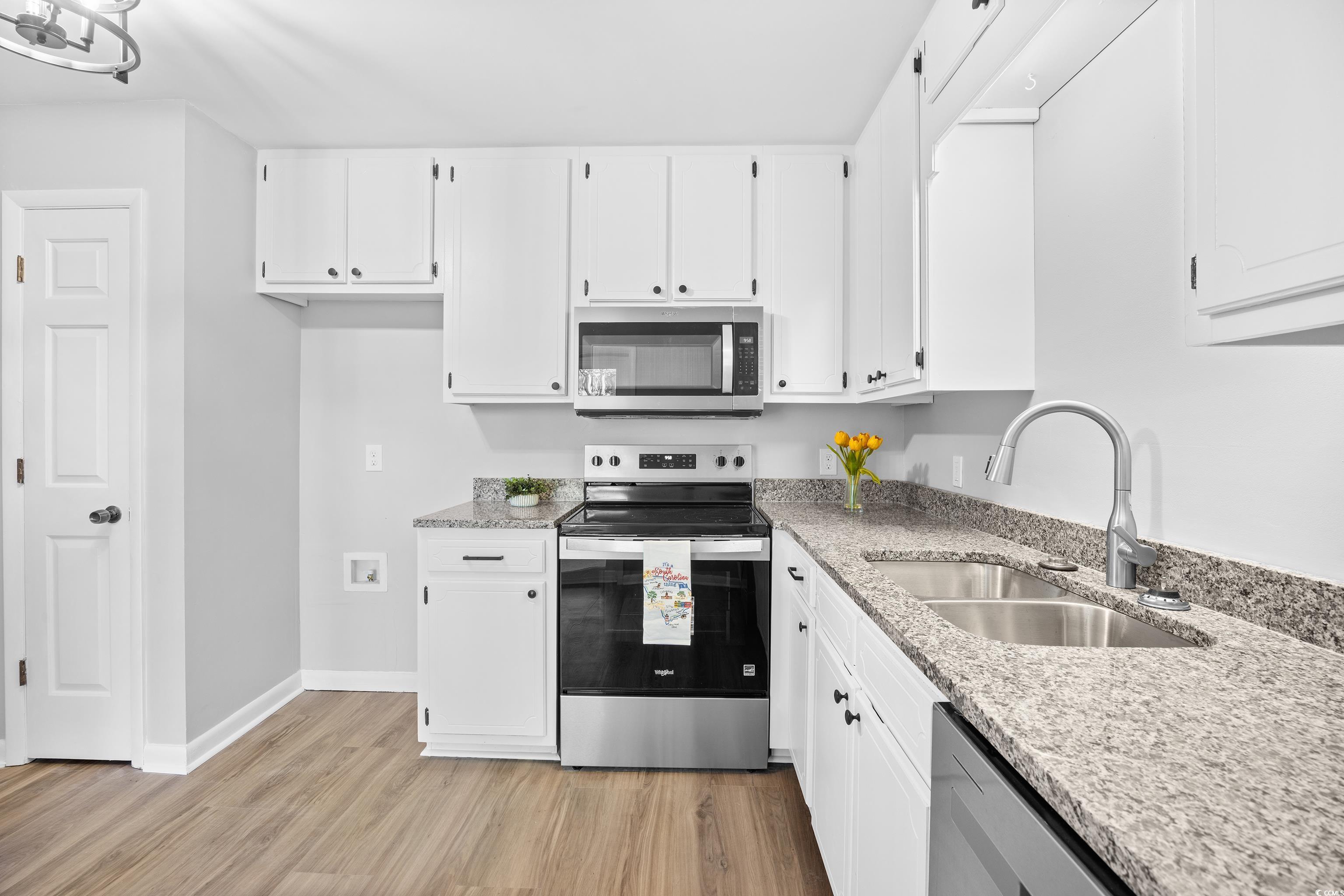 617 Surfside Drive Surfside Beach, SC 29575 - Photo 18 of 39 Kitchen with stainless steel appliances, light stone counters, white cabinets, and light wood-type flooring