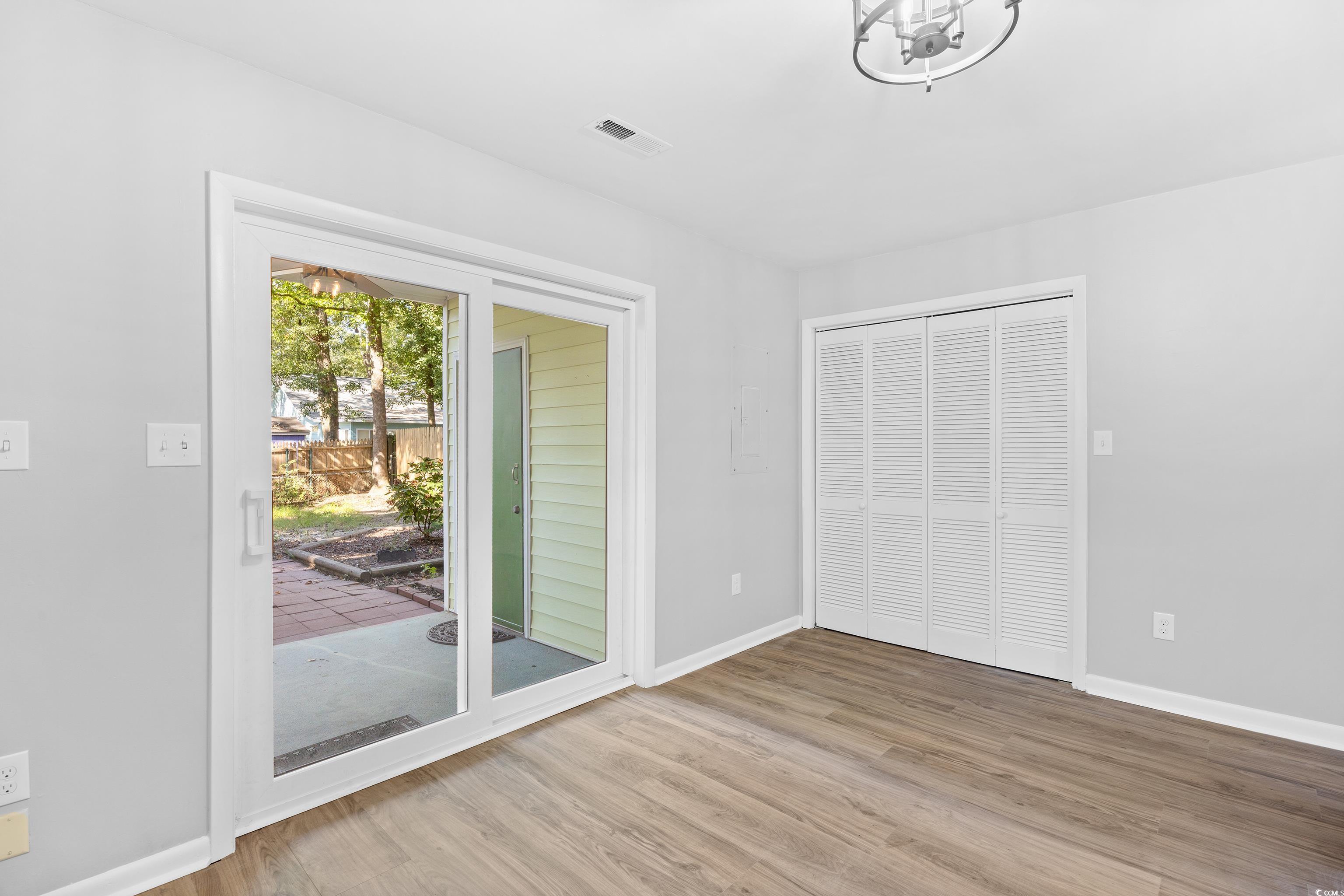 617 Surfside Drive Surfside Beach, SC 29575 - Photo 20 of 39 Unfurnished bedroom featuring light wood-style floors, access to exterior, and a closet