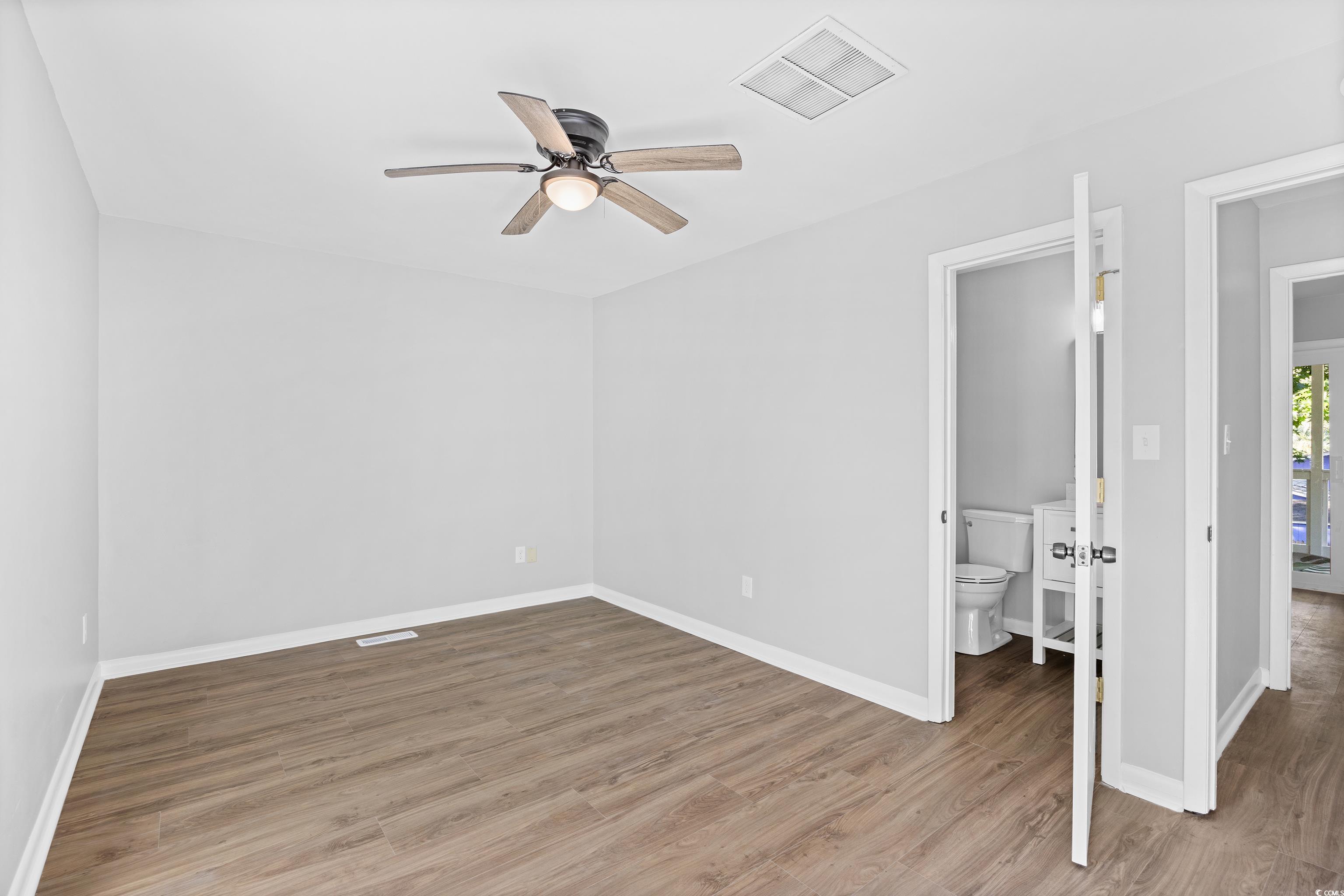 617 Surfside Drive Surfside Beach, SC 29575 - Photo 26 of 39 Unfurnished bedroom with light wood finished floors, ceiling fan, and ensuite bath