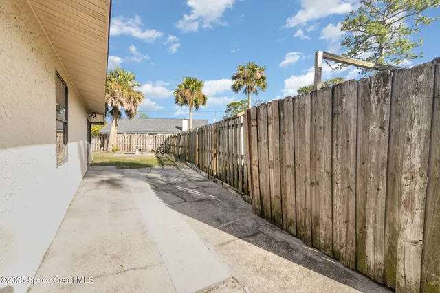 a view of a pathway of a building with wooden fence