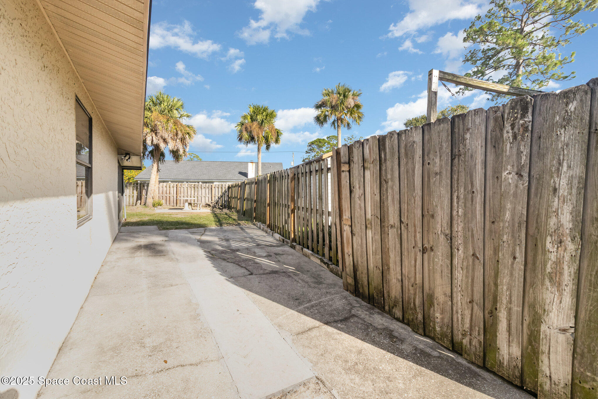 7065 Bright Avenue Cocoa, FL 32927 - Photo 4 of 12 a view of a pathway of a building with wooden fence