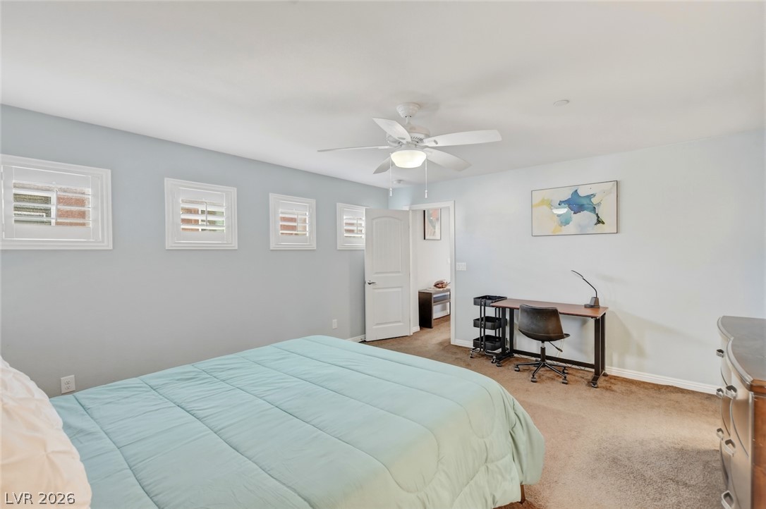 48 Jasmine Point Street Henderson, NV 89074 - Photo 39 of 62 A comfortable bedroom features carpet flooring, multiple windows, and a ceiling fan for optimal airflow.