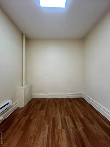 a view of a room with wooden floor and white walls