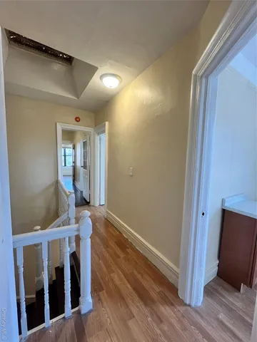 a view of a hallway with wooden floor and staircase