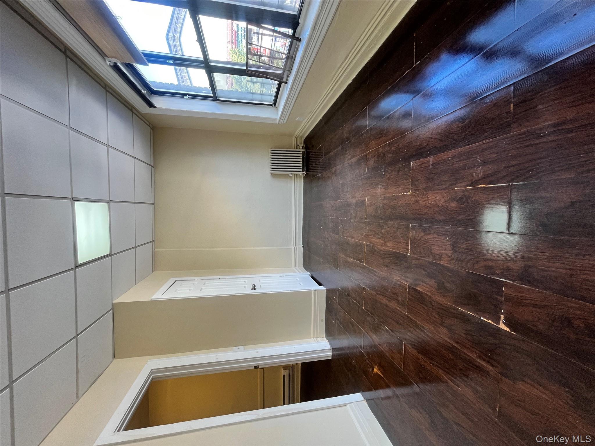 30 West Kingsbridge Road, Unit 3 Bronx, NY 10468 - Photo 5 of 14 an empty room with wooden floor and windows