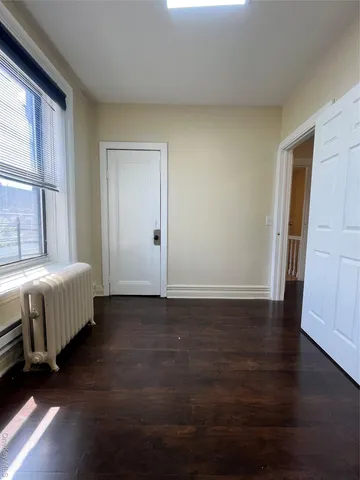 a spacious bedroom with a bed and wooden floor