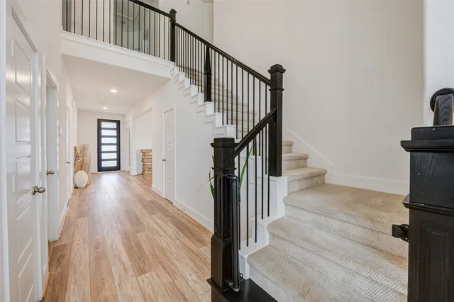 a view of a hallway with wooden floor and staircase