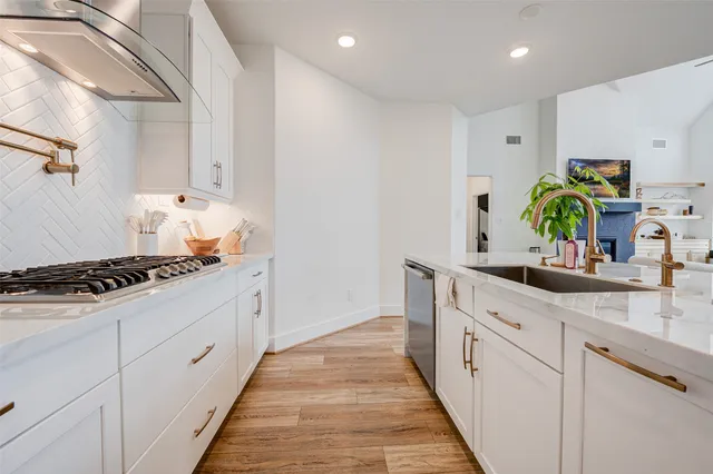 a kitchen with white cabinets and appliances