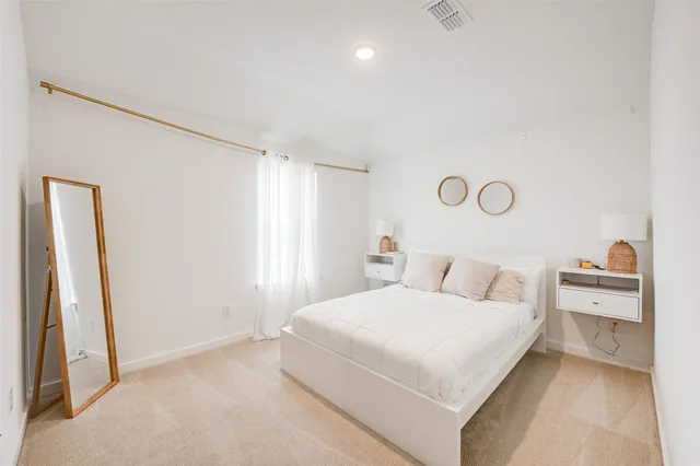 a bedroom with a bed and a large mirror