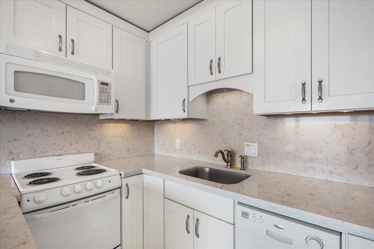 1403 Front Street, Unit 309 Lahaina, HI 96761 - Photo 11 of 33 a kitchen with white cabinets and white appliances