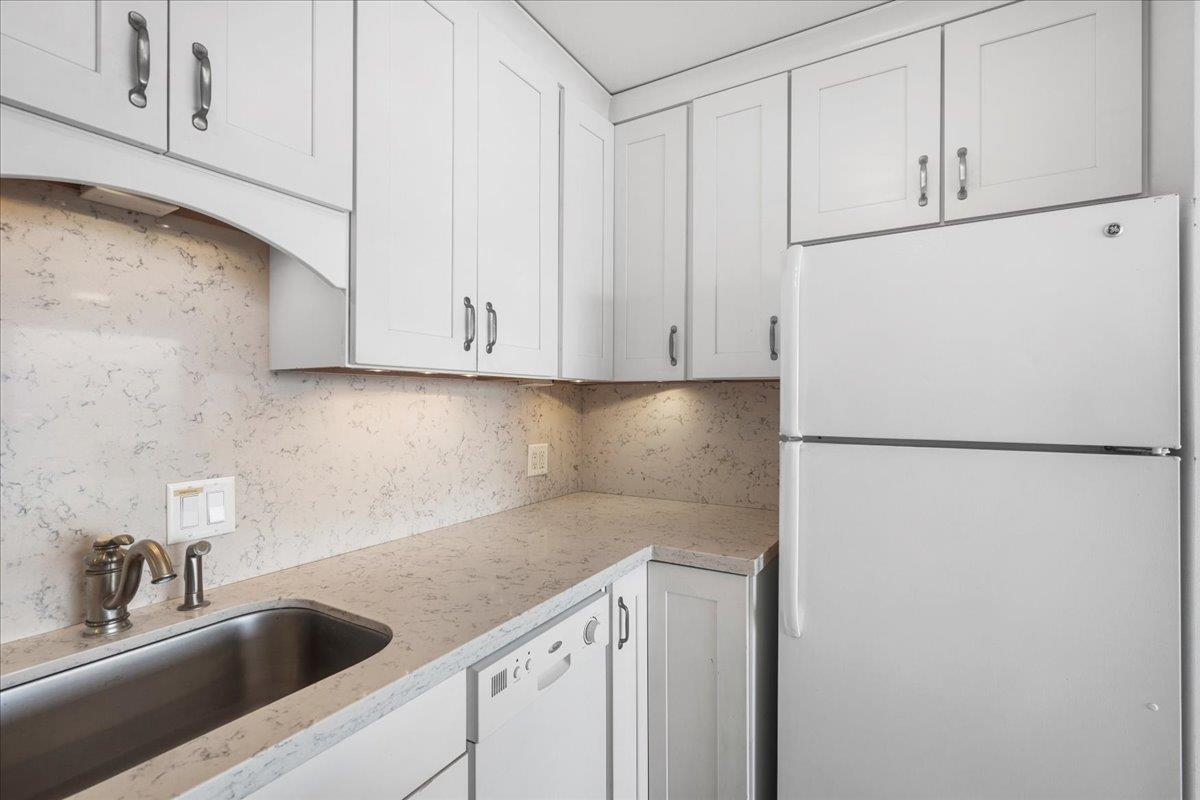 1403 Front Street, Unit 309 Lahaina, HI 96761 - Photo 12 of 33 a kitchen with refrigerator and cabinets