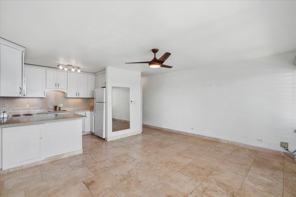 1403 Front Street, Unit 309 Lahaina, HI 96761 - Photo 8 of 33 a kitchen with kitchen island a sink stainless steel appliances and cabinets