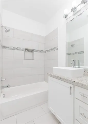 a bathroom with a granite countertop bathtub sink vanity and mirror