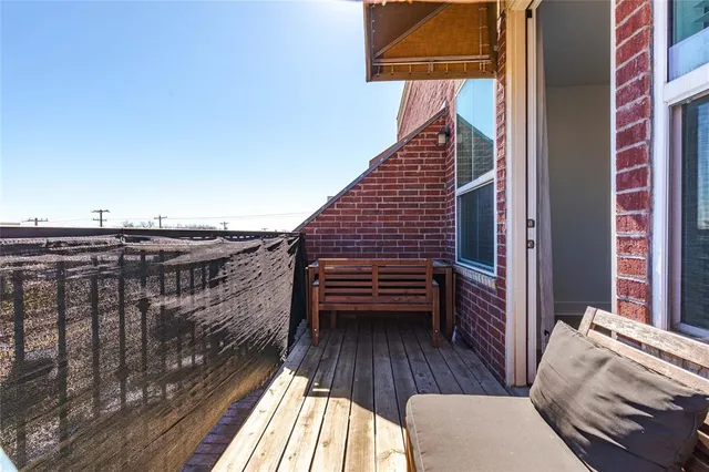 a view of a balcony with furniture and wooden floor