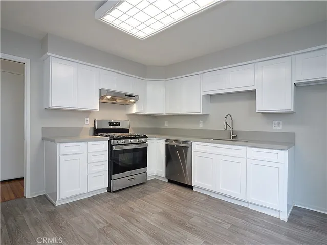 a kitchen with granite countertop a stove a sink and a microwave
