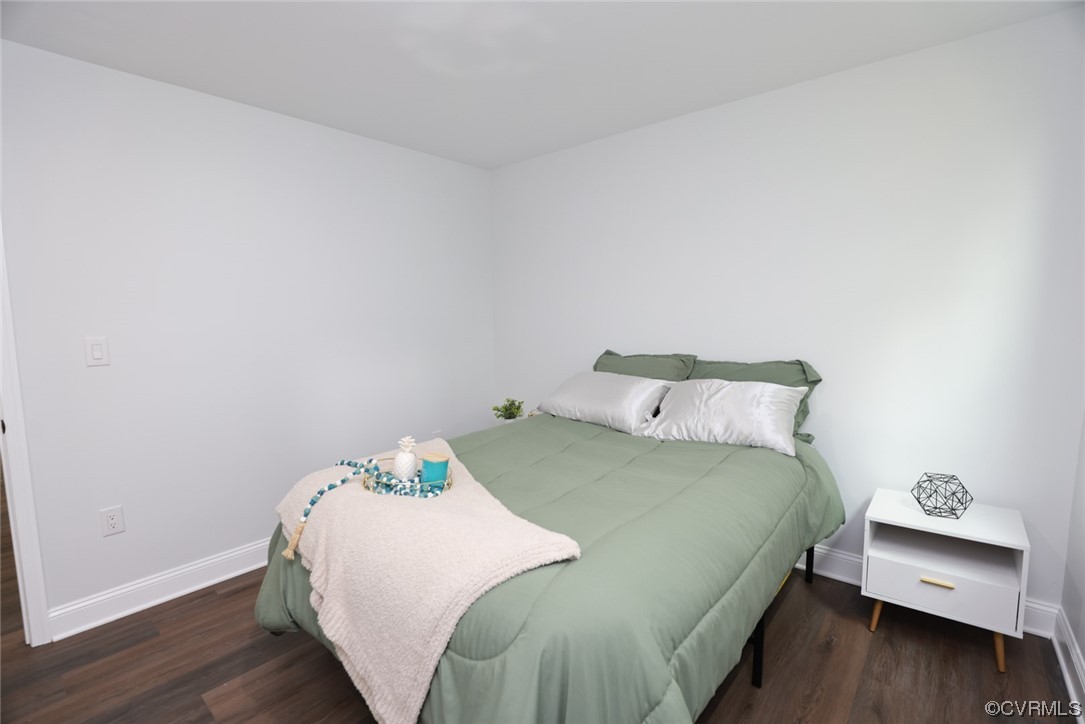 6830 Strathmore Road Richmond, VA 23237 - Photo 14 of 47 a bedroom with a bed and a wooden floor