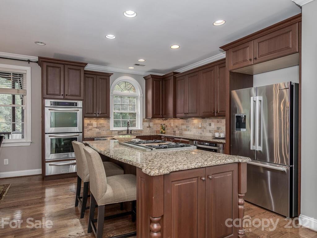 3115 Planters Ridge Road Charlotte, NC 28270 - Photo 13 of 44 a kitchen with stainless steel appliances granite countertop a refrigerator a stove a sink dishwasher and microwave with wooden cabinets