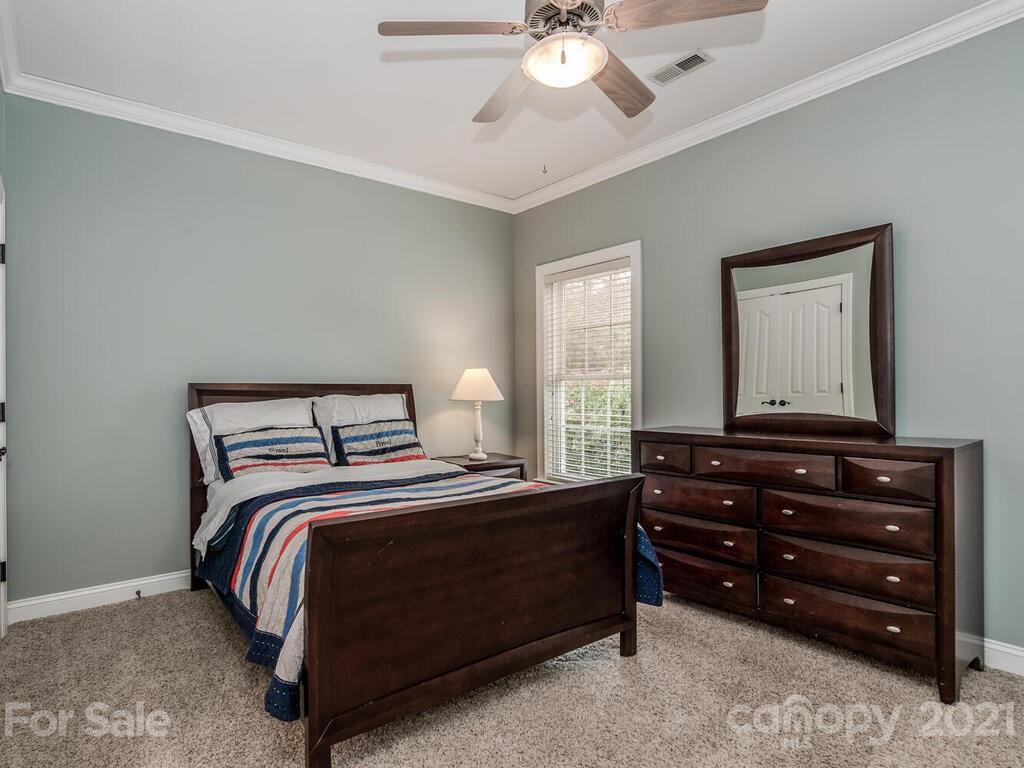 3115 Planters Ridge Road Charlotte, NC 28270 - Photo 23 of 44 a bedroom with a bed and a chandelier